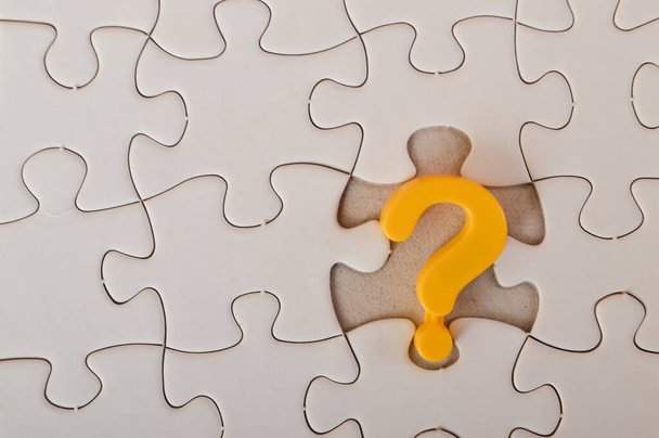 L'image d'un point d'interrogation jaune sur un fond de puzzle transmet les idées de résolution de problèmes, de confusion, de recherche de solutions et de conseil.. - Photo, image
