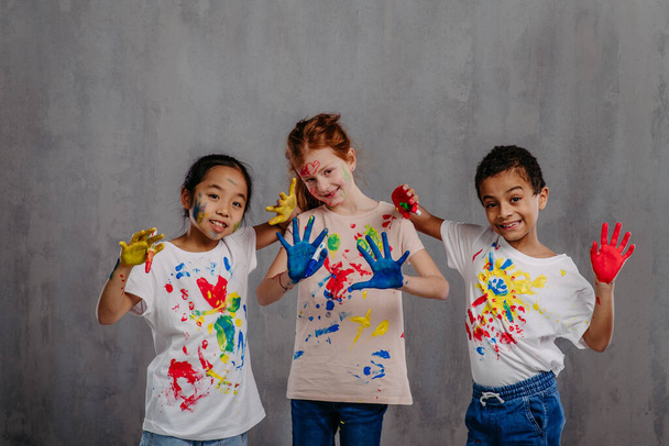 Portrait of happy kids with finger colours and painted t-shirts. - Zdjęcie, obraz