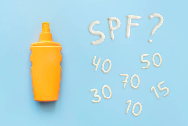 sunscreen, orange bottle, sun protection on blue background, copy space. spray to protect against sunburn. different spf values for sun protection cream - Fotoğraf, Görsel