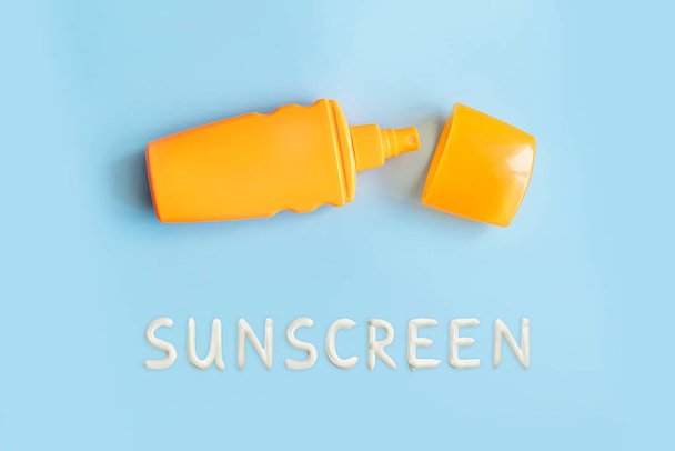 sunscreen, orange bottle, sun protection on blue background, copy space. spray to protect against sunburn. - Фото, изображение