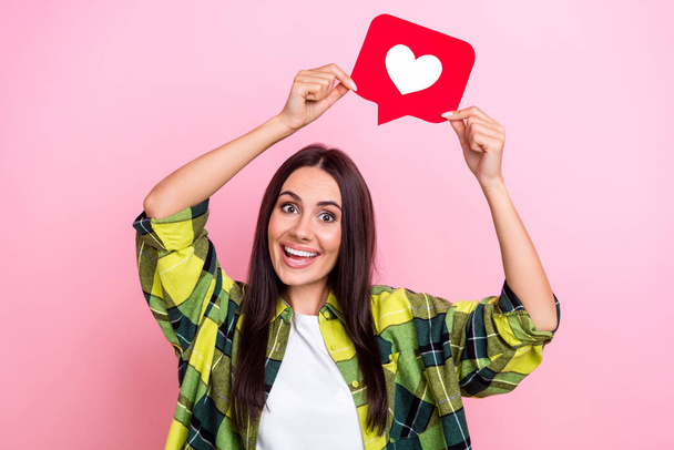 Photo of cute shiny woman dressed plaid shirt holding heart like feedback isolated pink color background. - Fotografie, Obrázek