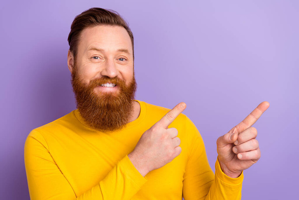 Portrait of young good mood guy wear yellow pullover point fingers empty space opening barbershop isolated on purple color background. - Foto, immagini