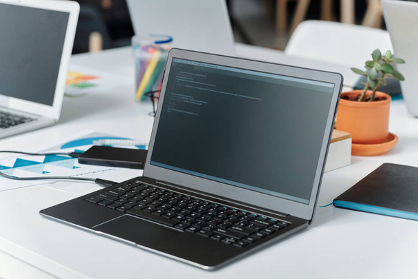Close-up de laptop com códigos no monitor na mesa do programador no escritório de TI - Foto, Imagem