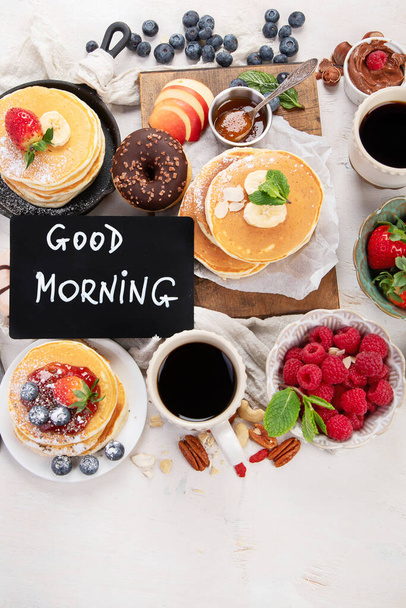 Continental breakfast. Coffee, jam, pancakes, maffins. White background. Family breakfast table. Top view. - Фото, зображення