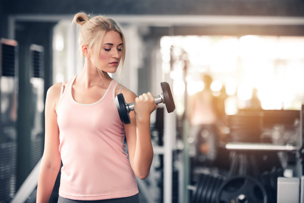 Sport Caucasian Woman Lifting Dumbbells and Workout Exercises in Gym - Lifestyle Concept - Photo, image