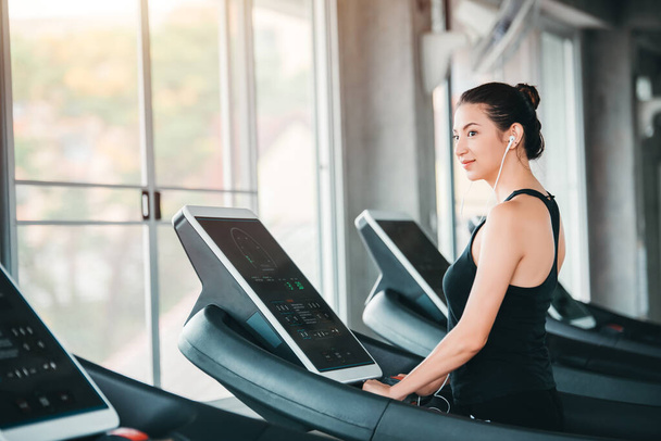 Mooie blanke sportvrouw workout oefening op loopband in Gym - Lifestyle en gezondheidszorg concept - Foto, afbeelding