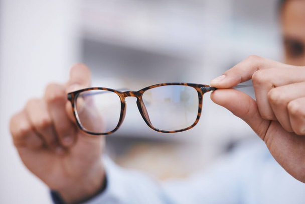 Optometrie, handen en opticien met bril naar keuze, gezichtsvermogen en kaderbesluit. Geven, tonen en een man met voorgeschreven brillen voor een pasvorm, visie en service tijdens een consult. - Foto, afbeelding