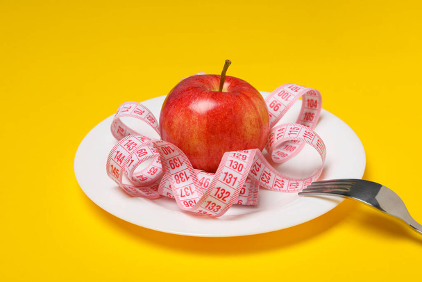 Έννοια της απώλειας βάρους και της υγιεινής διατροφής με μήλο και μεζούρα - Φωτογραφία, εικόνα