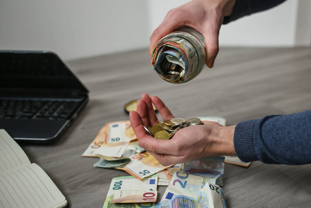Taking money from saving jar - Zdjęcie, obraz