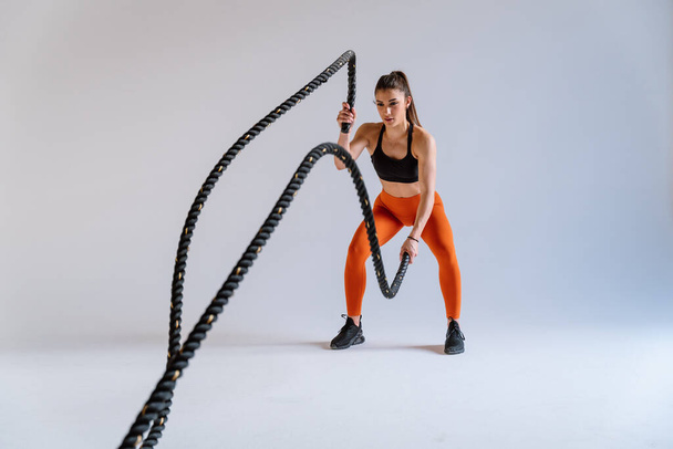 Young female athlete training in a gym using sport equipment. Fit woman working out . Concept about fitness, wellness and sport preparation. - Φωτογραφία, εικόνα