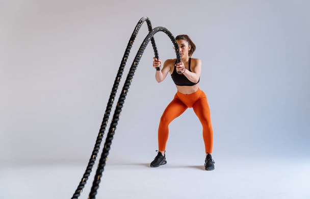 Young female athlete training in a gym using sport equipment. Fit woman working out . Concept about fitness, wellness and sport preparation. - Foto, Imagen