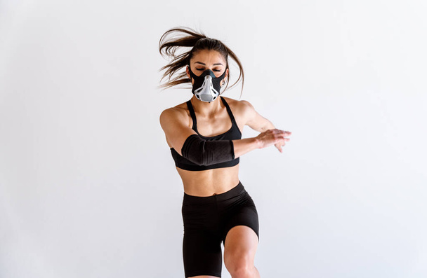 Young female athlete training in a gym using sport equipment. Fit woman working out . Concept about fitness, wellness and sport preparation. - 写真・画像