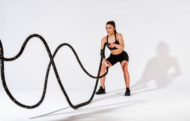 Young female athlete training in a gym using sport equipment. Fit woman working out . Concept about fitness, wellness and sport preparation. - Foto, imagen