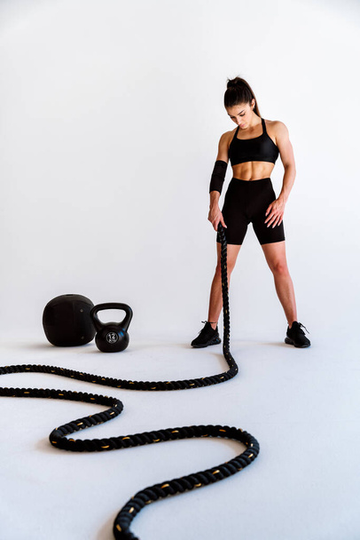 Young female athlete training in a gym using sport equipment. Fit woman working out . Concept about fitness, wellness and sport preparation. - Zdjęcie, obraz