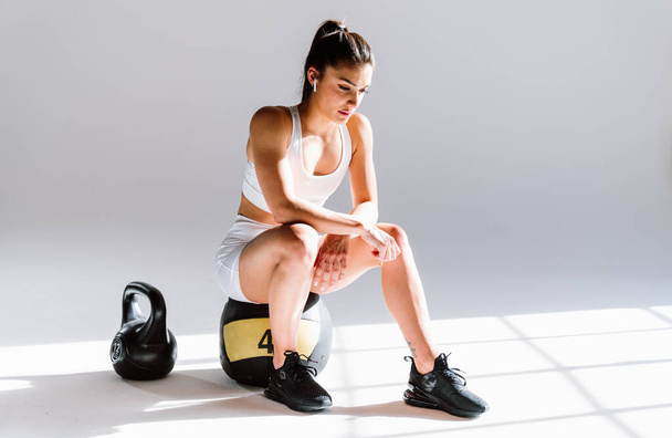 Young female athlete training in a gym using sport equipment. Fit woman working out . Concept about fitness, wellness and sport preparation. - Fotoğraf, Görsel