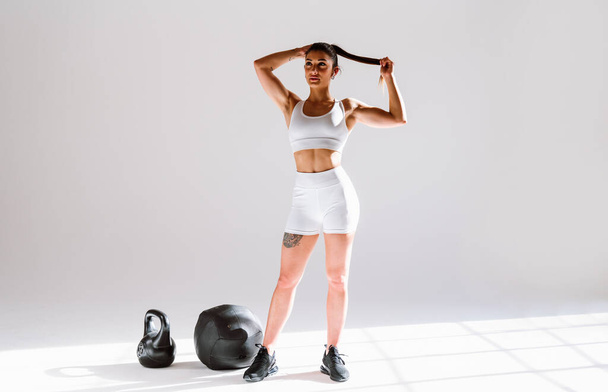 Young female athlete training in a gym using sport equipment. Fit woman working out . Concept about fitness, wellness and sport preparation. - Foto, Bild