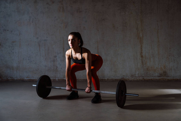 Young female athlete training in a gym using sport equipment. Fit woman working out . Concept about fitness, wellness and sport preparation. - Photo, Image