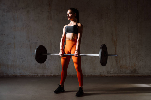 Young female athlete training in a gym using sport equipment. Fit woman working out . Concept about fitness, wellness and sport preparation. - Valokuva, kuva