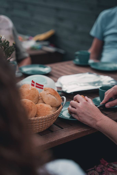 A vertical shot of a fluffy round bread with Denmark flag on them - Фото, зображення