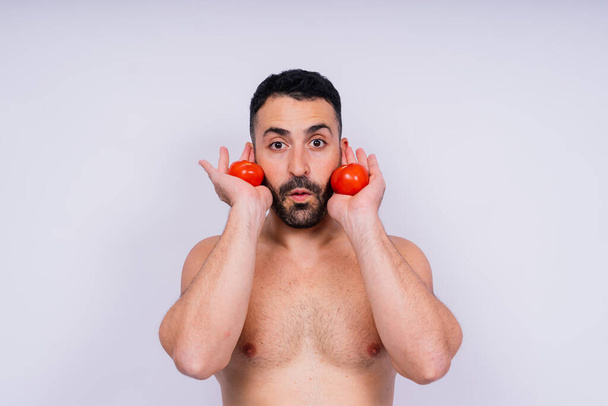 Full isolated studio picture from a young naked man with underwear and tomatoes - Zdjęcie, obraz