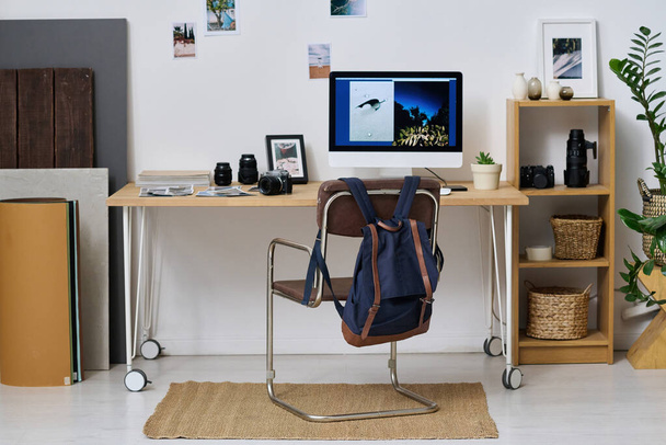 Modern studio with workplace of photographer with computer monitor on table for retouching professional photos - Foto, afbeelding