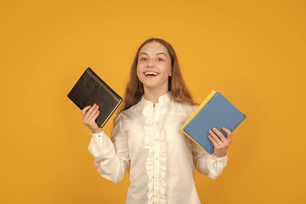happy kid holding school homework on yellow background, back to school. - Foto, Imagem