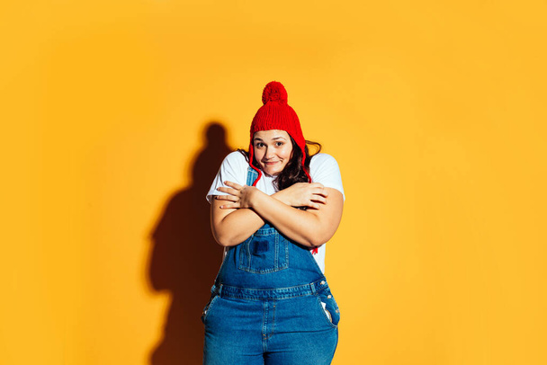 Plus size woman model posing in studio and having fun on colored backgrounds. Hard direct studio light shots - Фото, изображение