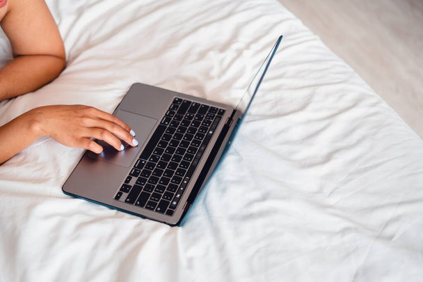 Kaukázusi nő feküdt az ágyon laptoppal, Laptop üres ágyon - Fotó, kép