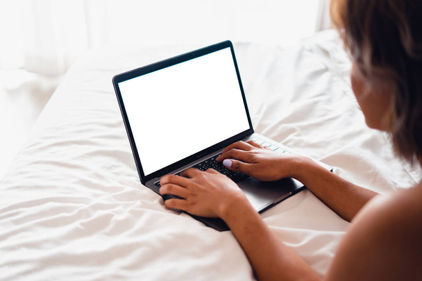 Valkoihoinen nainen makaa sängyllä kannettavalla tietokoneella, Laptop tyhjällä sängyllä - Valokuva, kuva