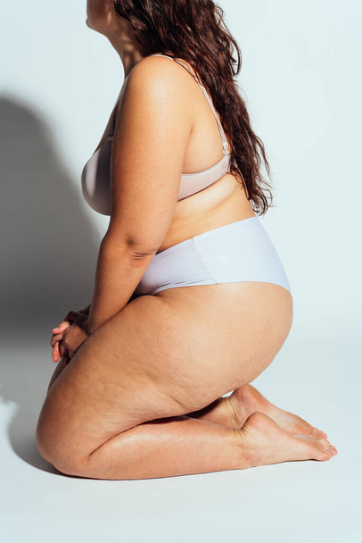 Plus size woman posing in studio in lingerie. Model on white background. Hard light studio shot - Foto, Bild