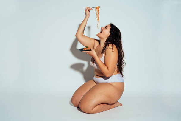 Plus size woman posing in studio in lingerie. Model on white background. Hard light studio shot - Fotografie, Obrázek