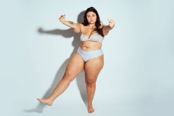 Plus size woman posing in studio in lingerie. Model on white background. Hard light studio shot - Foto, Imagem