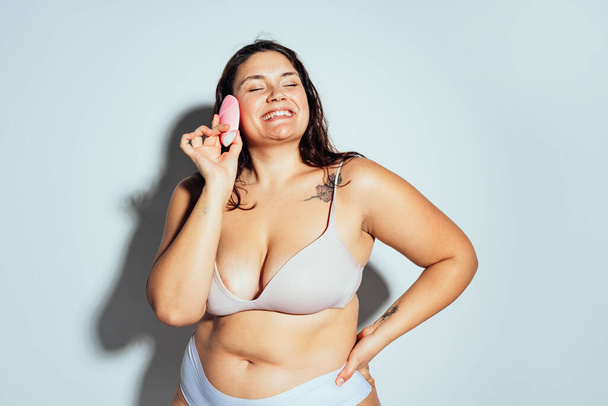 Plus size woman posing in studio in lingerie. Model on white background. Hard light studio shot - Photo, Image