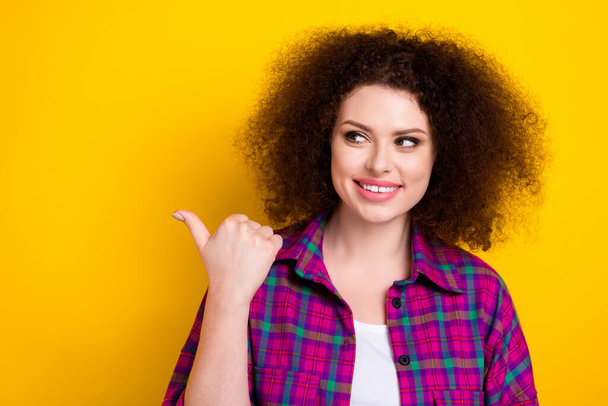 Photo of young adorable woman wear magenta shirt directing finger empty space shopping proposition cosmetics isolated on yellow color background. - 写真・画像