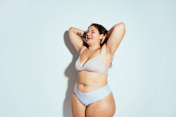 Plus size woman posing in studio in lingerie. Model on white background. Hard light studio shot - Φωτογραφία, εικόνα