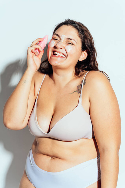 Plus size woman posing in studio in lingerie. Model on white background. Hard light studio shot - Фото, изображение