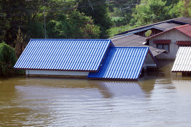 Річковий будинок, який постраждав від великої повені, рівень води якого досяг даху будинку
. - Фото, зображення