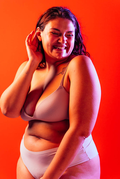 Plus size woman posing in studio in lingerie. Model on colored background. Hard light studio shot - Fotoğraf, Görsel