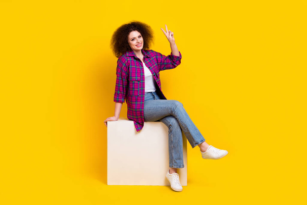 Full length photo of friendly pretty woman dressed plaid shirt showing v-sign isolated yellow color background. - Fotografie, Obrázek