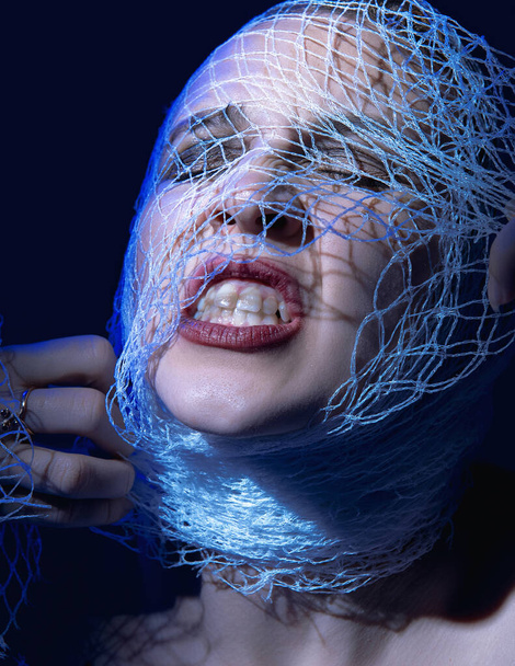 close-up portrait of a woman in blue light. the head is wrapped  - Fotó, kép