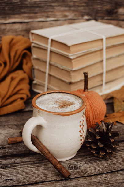 Hot spicy coffee and pile of old books on wooden background - Foto, Imagen