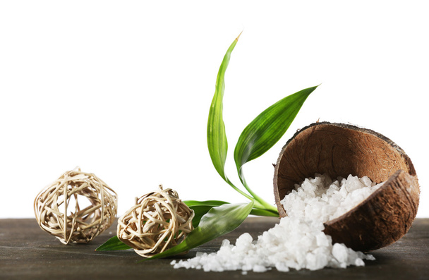 Kokosový shell mořské soli s proutěná koule a zelené lístky izolovaných na bílém - Fotografie, Obrázek