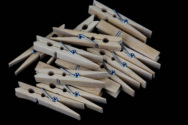 Ένας σωρός από ξύλινα μανταλάκια που απομονώνονται σε μαύρο φόντο - Φωτογραφία, εικόνα