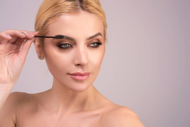Perfect eyebrows. Natural beauty brows. Eyebrows coloring and lamination. Woman combing eyebrows. Makeup and cosmetology concept. Eyebrow shape modeling - 写真・画像
