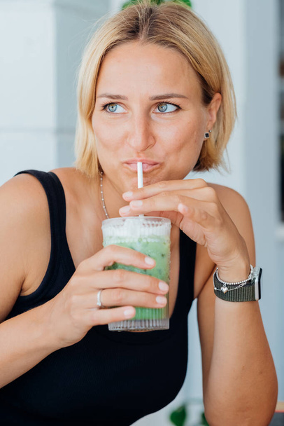 Porträt schöne blonde Frau trinkt kalten Eiskaffee und genießt den Sommerurlaub  - Foto, Bild