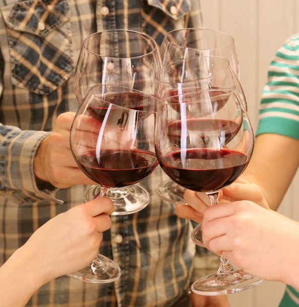 Tungur gözlük ellerinde renk ahşap plakalar arka plan üzerinde kırmızı şarap - Fotoğraf, Görsel
