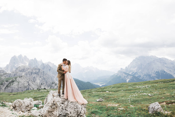 Beautiful gorgeous bride posing to groom and having fun near at mountains with amazing view, space for text, wedding couple. - Foto, imagen