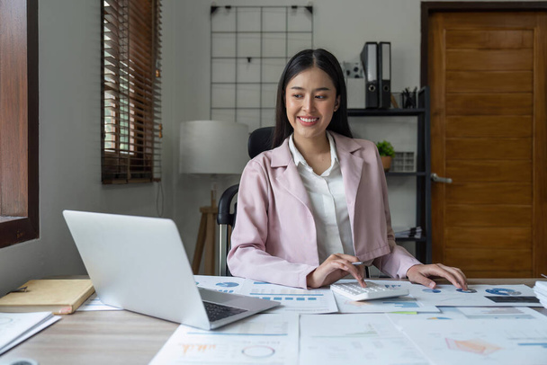 Азиатская деловая женщина в домашнем офисе, занимается планированием анализа финансового отчета, инвестицией бизнес-плана. - Фото, изображение