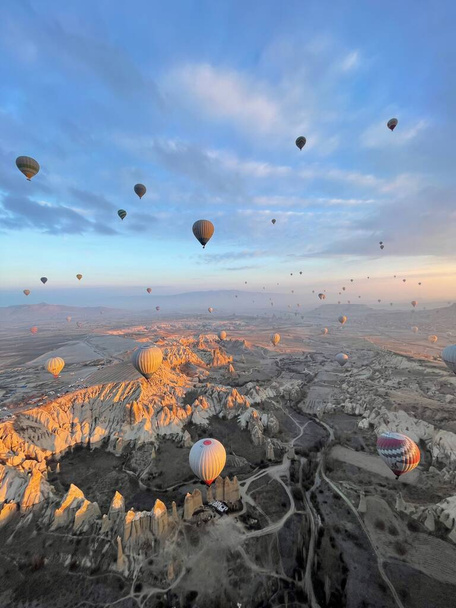 A vertical shot of hot air balloons flying over Kapadokya Nevsehir at sunset, Turkey - Φωτογραφία, εικόνα