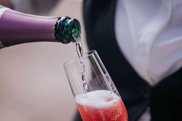 A closeup shot of a person pouring champagne into a glass - Foto, Bild